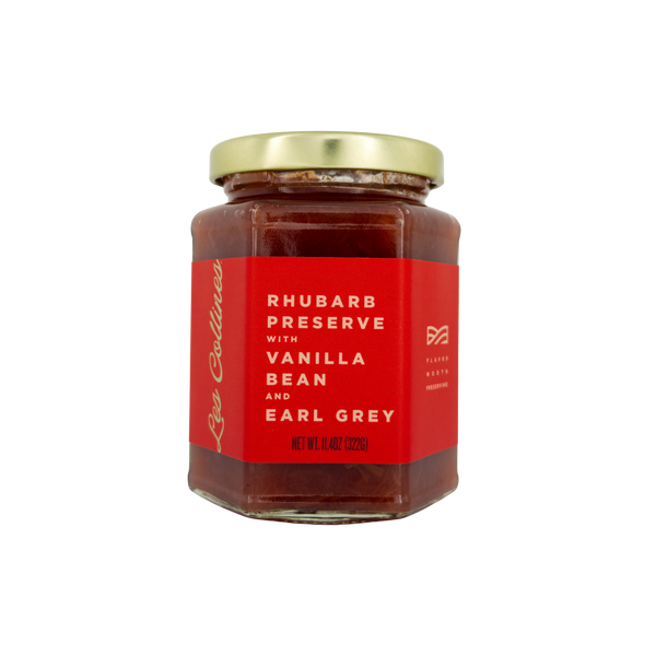 Jar of rhubarb preserve with vanilla bean and earl grey on a white background