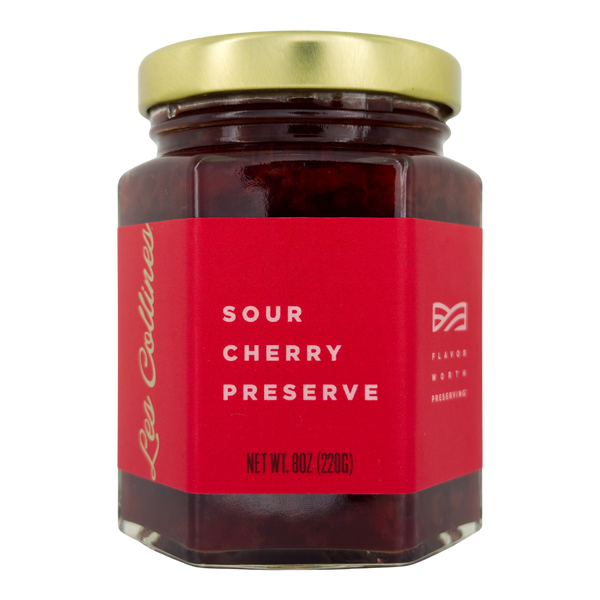 Jar of sour cherry preserve with a red label on a white background