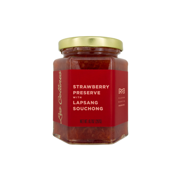Jar of strawberry preserve with lapsang souchong on a white background