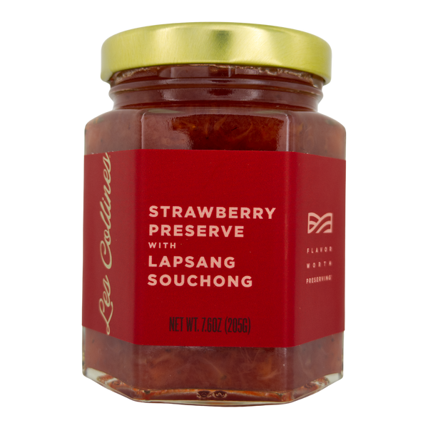 Jar of strawberry preserve with lapsang souchong on a white background